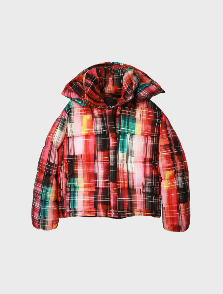 A model showcases a vibrant plaid coat and skirt, part of the Padded_Malmo - 9019 Tutti Frutti collection.
