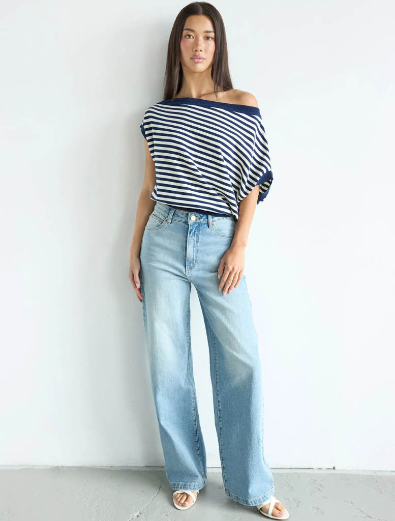 A woman in wide-legged jeans and a striped top, showcasing the 94 High & Wide style by Jody Blue.
