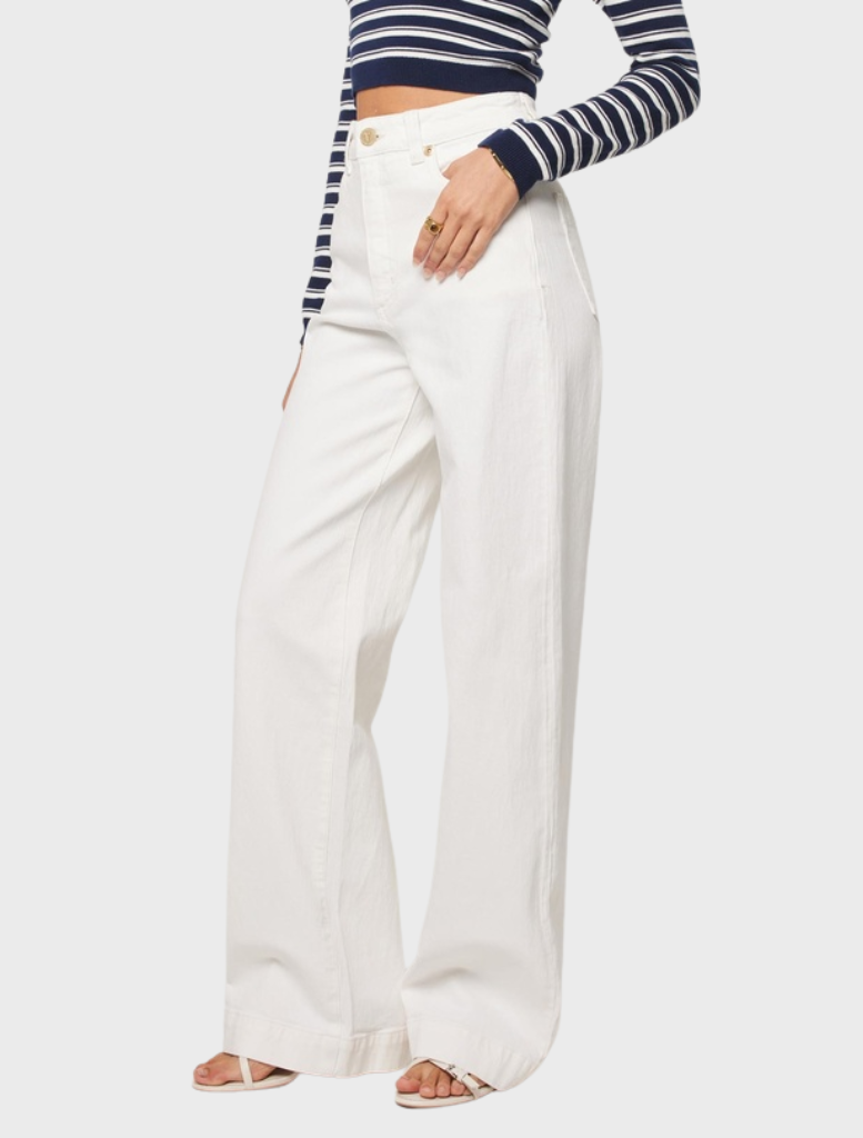 Fashion model wearing white wide-leg pants paired with a striped crop top, exuding a trendy look.
