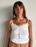Woman wearing a white lace top and gold jewelry against a plain background Cyprus Necklace Gold Susmies