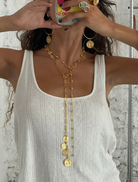 Person wearing a gold necklace with a white top against a neutral background Cyprus Necklace Gold Susmies