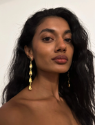 Woman wearing gold earrings with a plain background  Tears On My Own Earrings by Susmies