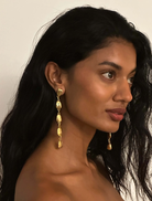 Woman wearing gold earrings with a neutral background  Tears On My Own Earrings by Susmies