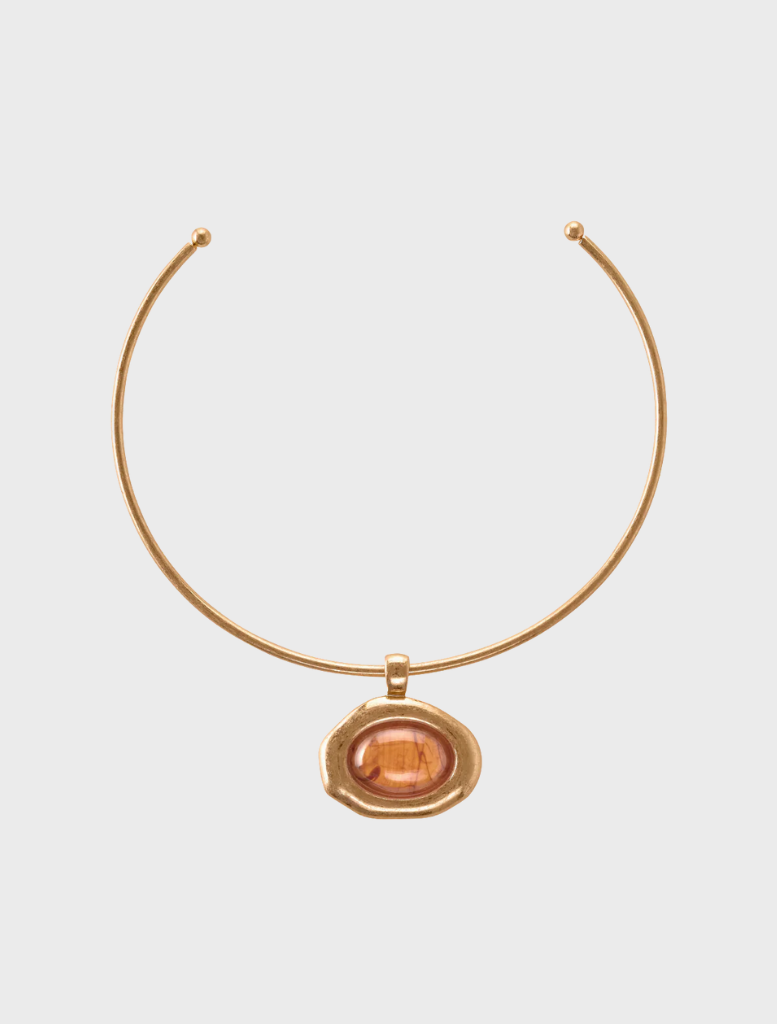 A gold necklace featuring a prominent orange stone at its center, elegantly designed for a striking appearance.
