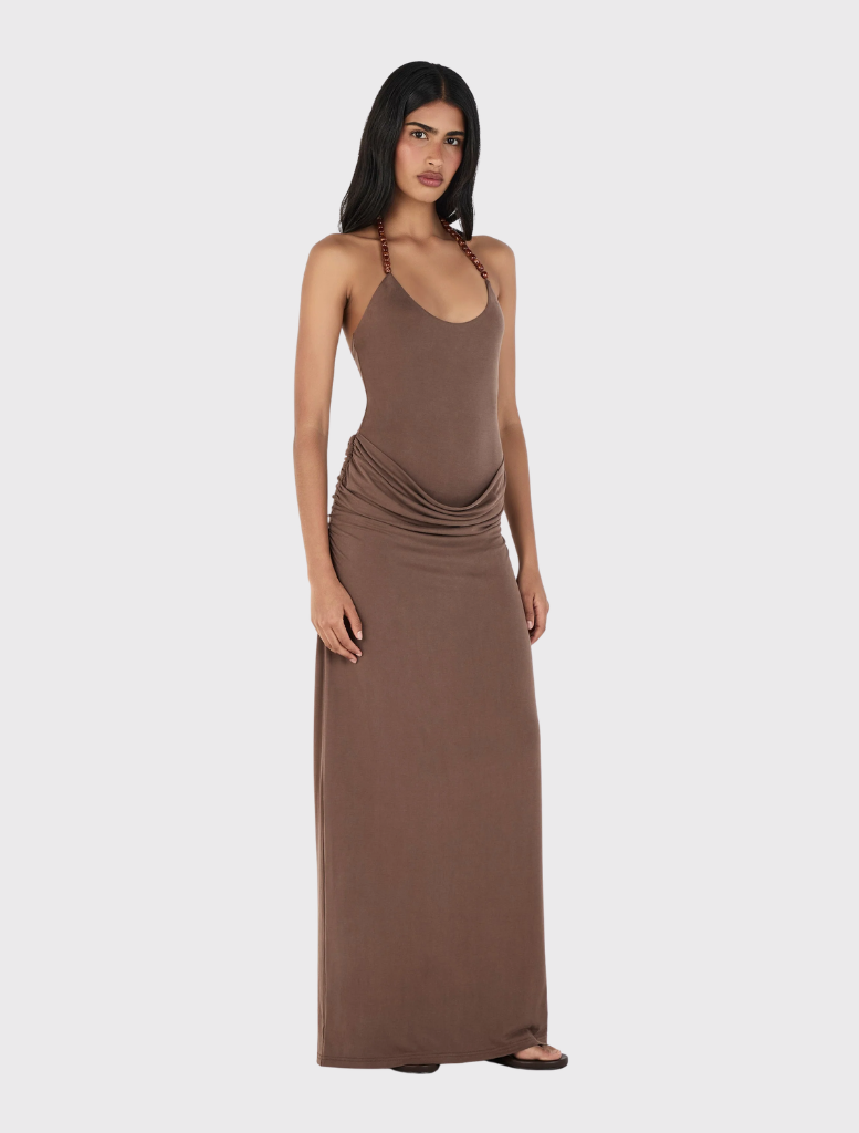 Elegant chocolate halterneck maxi dress with a fitted bodysuit, draped skirt, and gathered ruching at the hips.