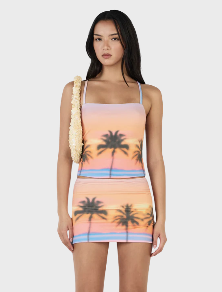 A picturesque sunset on Sunset Boulevard, featuring a colorful sky and palm trees against the fading light.