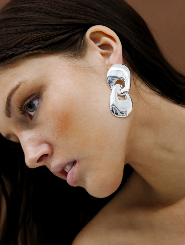 A pair of silver earrings with a sleek circular design, perfect for adding a touch of elegance.