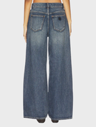A person walking in the 95 Super Baggy jeans, illustrating their comfortable fit and contemporary style in an urban backdrop.