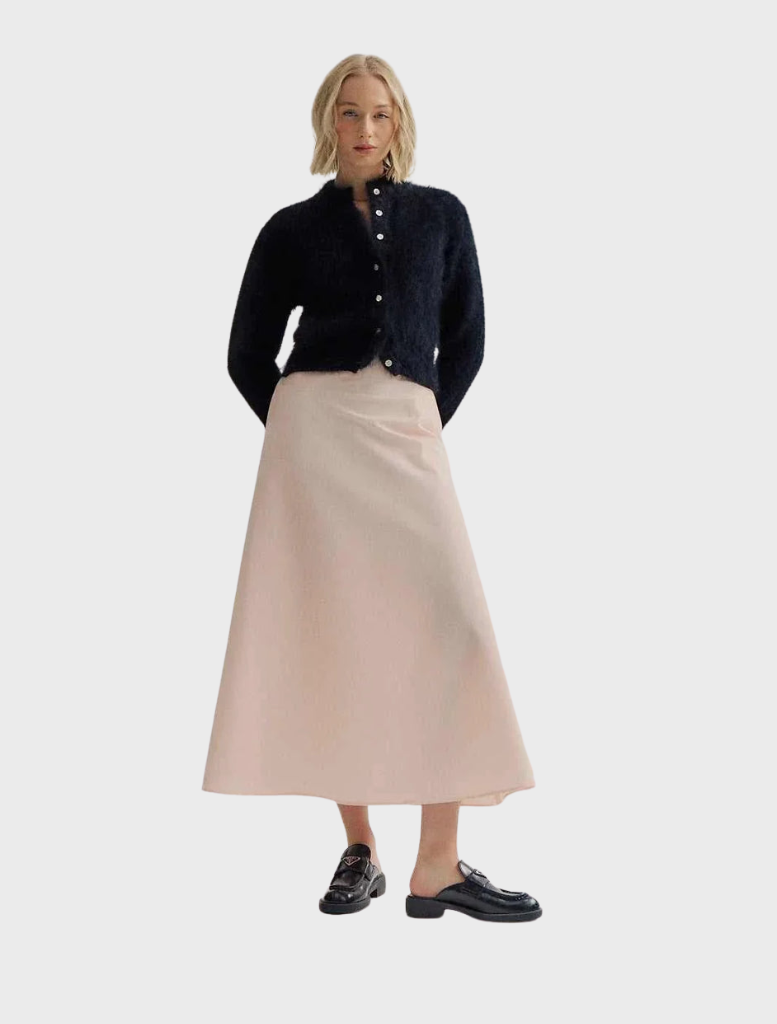 Black Bella Cashmere Cardigan displayed on a hanger, showcasing its soft texture and elegant design.