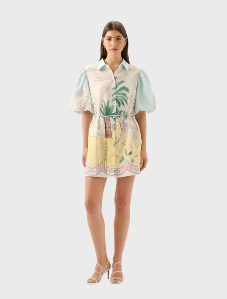 Model wearing the Berkley Mini Dress - Utopia, featuring a vibrant design of palm trees and flowers.