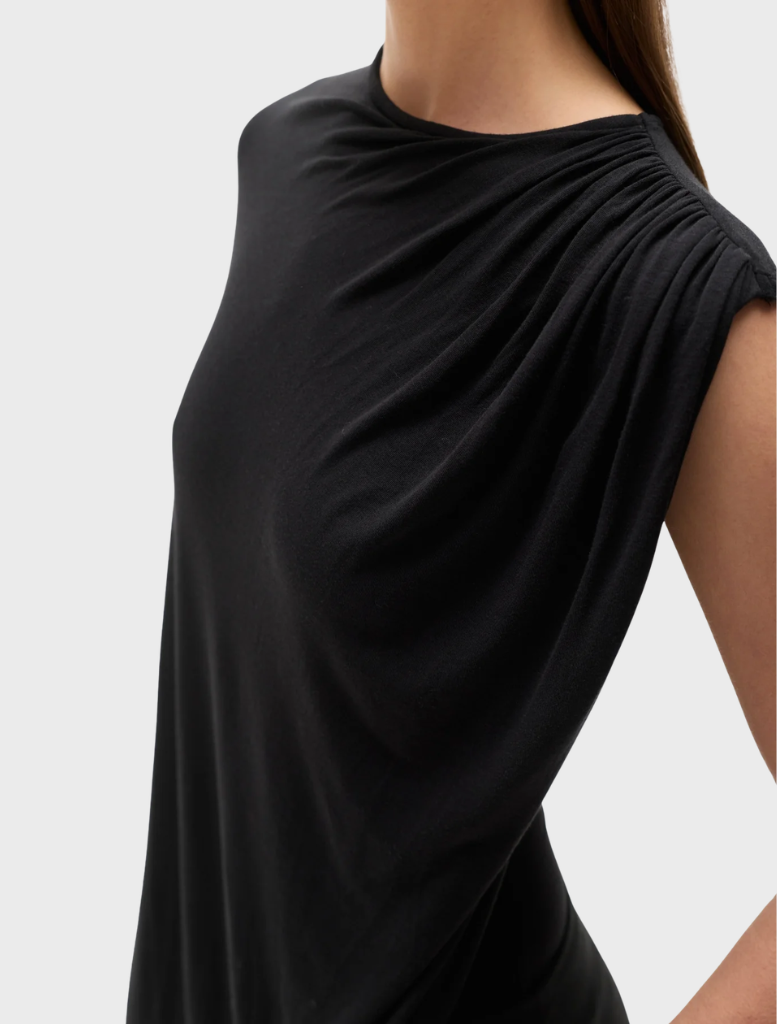 A stylish black bodysuit called "Birdie" presented on a model, highlighting its contemporary silhouette.