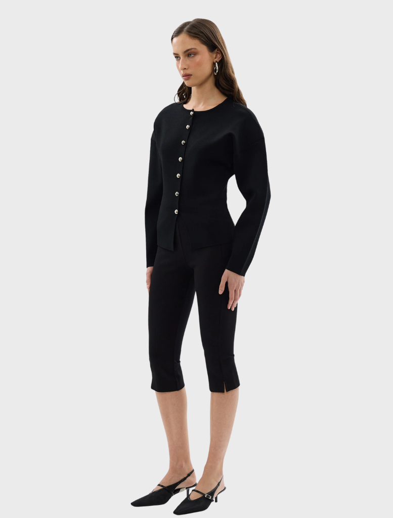 Black Bronte knit cardigan hanging against a neutral background, illustrating its versatile fashion appeal.