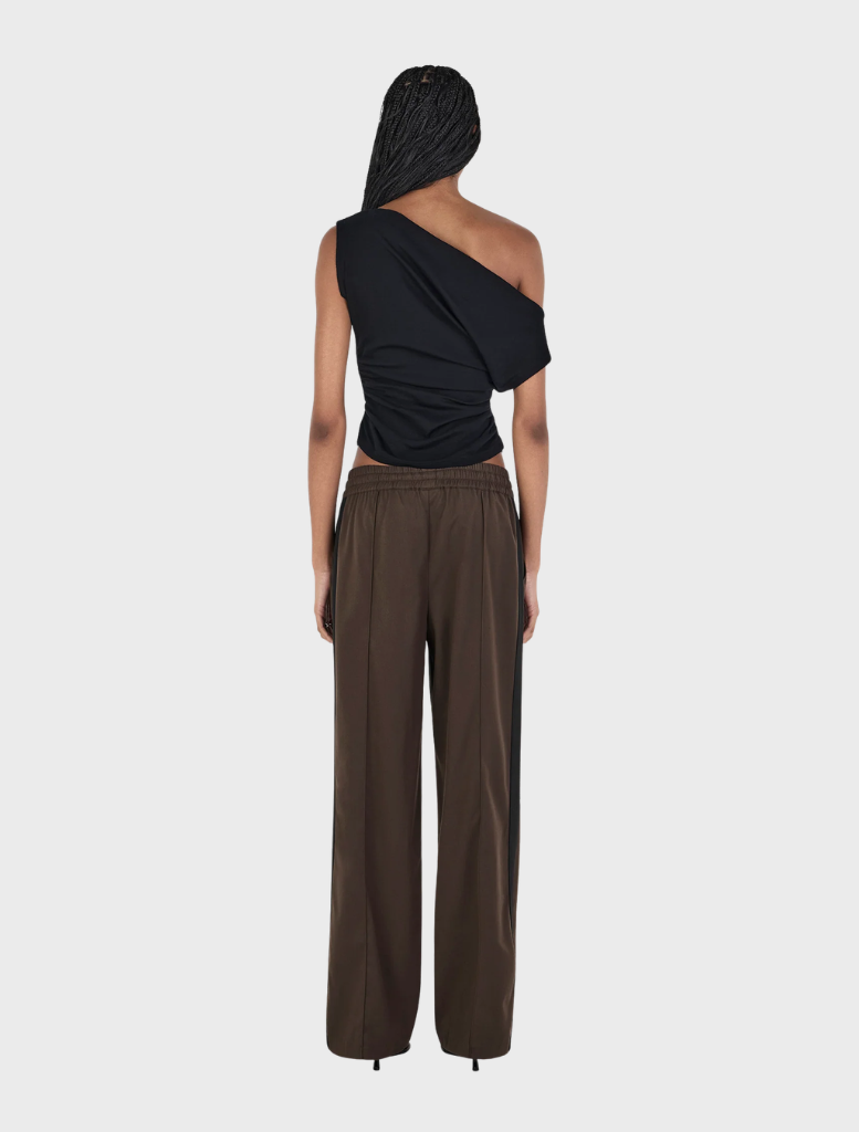A black wool top by Pip, featuring a classic cut, hanging against a neutral background.