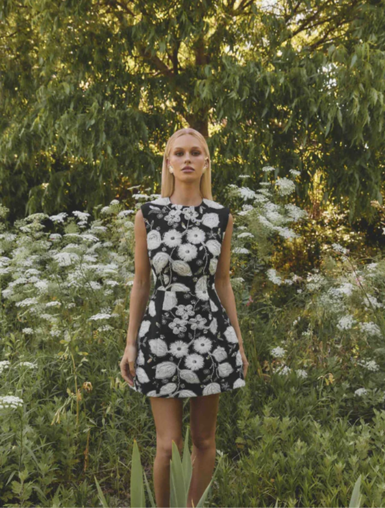 Elegant black and white Carol Tulip mini dress with a floral pattern and a flared silhouette, ideal for stylish outings.