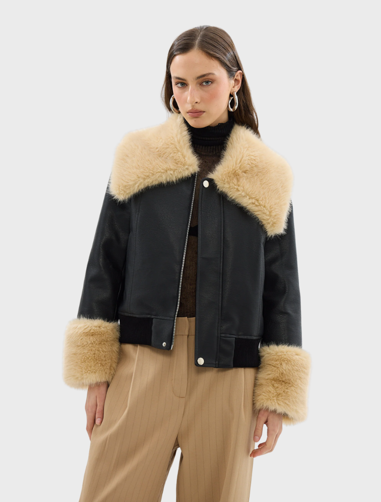 A black Willow jacket hanging, highlighting its modern style and elegant silhouette.