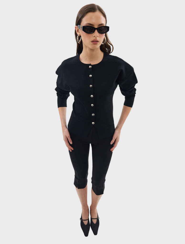 Black Bronte knit cardigan hanging against a neutral background, illustrating its versatile and chic appearance.