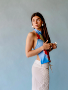 A woman in a vibrant floral outfit takes a selfie, showcasing her joyful demeanor.