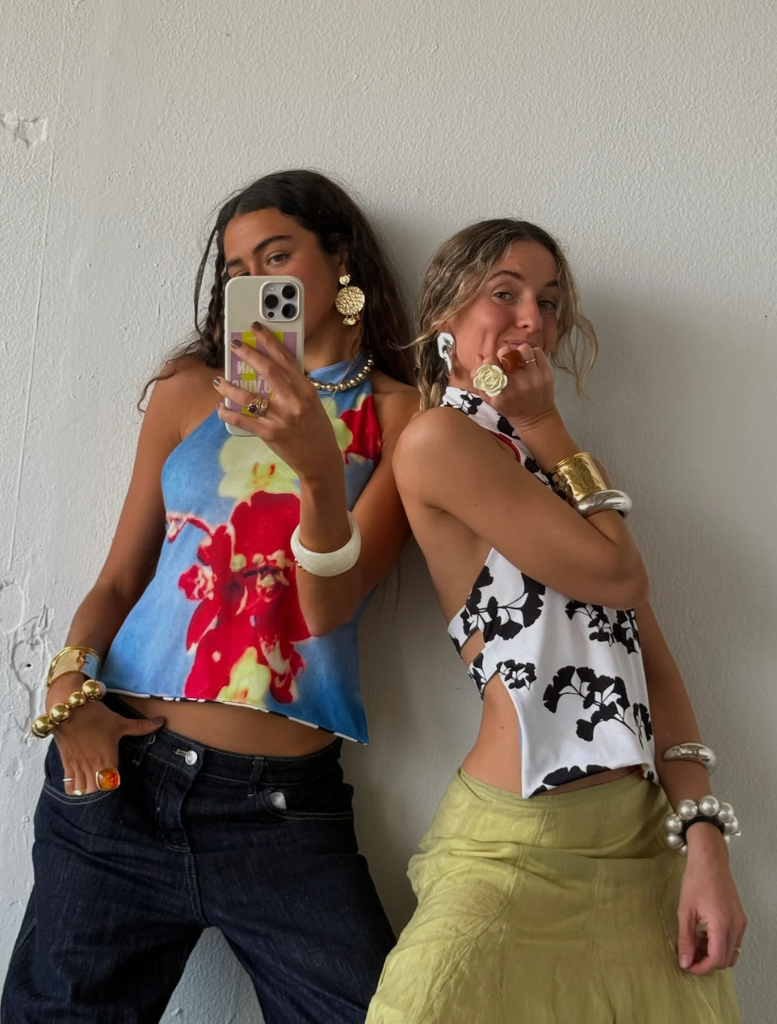 Two stylish tops adorned with colorful flowers, shown next to each other.