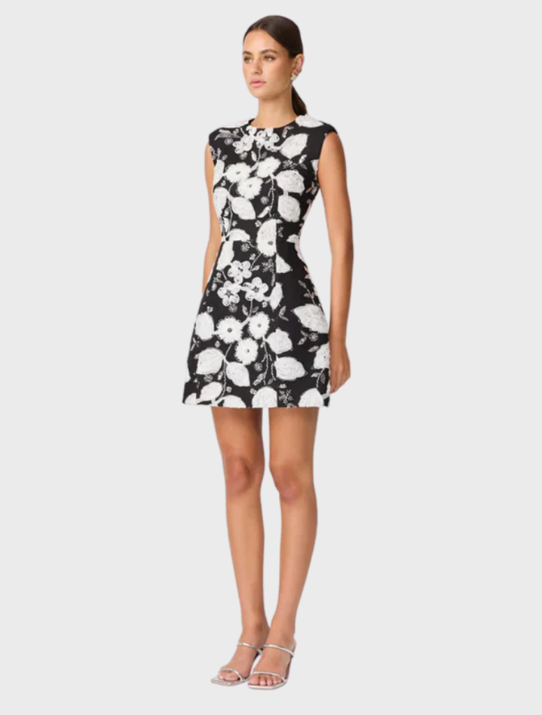 Stylish black and white Carol Tulip mini dress with a floral motif and flared hem, perfect for summer gatherings.