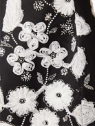 Fashionable black and white Carol Tulip mini dress featuring a floral design and flared skirt, great for casual wear.