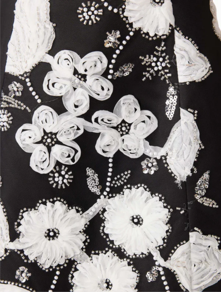 Fashionable black and white Carol Tulip mini dress featuring a floral design and flared skirt, great for casual wear.