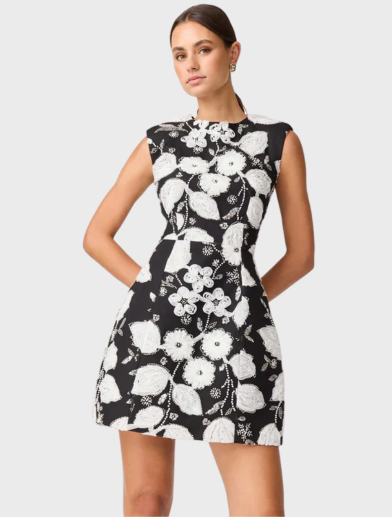Elegant black and white Carol Tulip mini dress with a floral pattern and a flared silhouette, ideal for stylish outings.