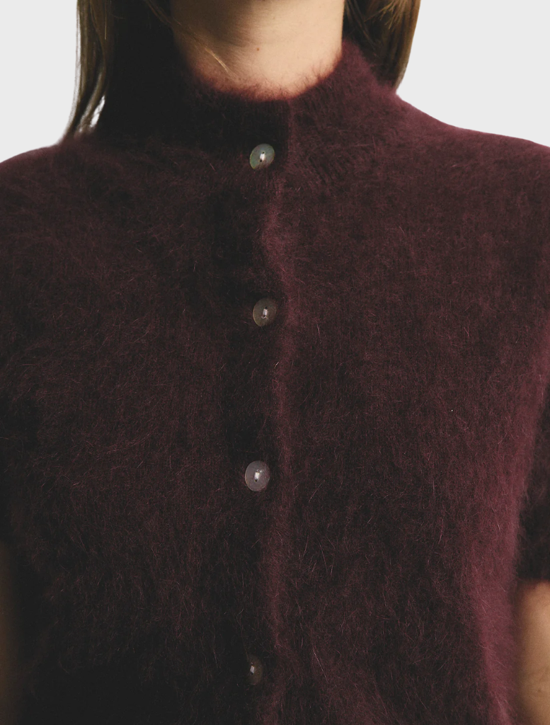 Claudia's short sleeve cardigan in rich aubergine, offering a blend of comfort and elegance in cashmere fabric.