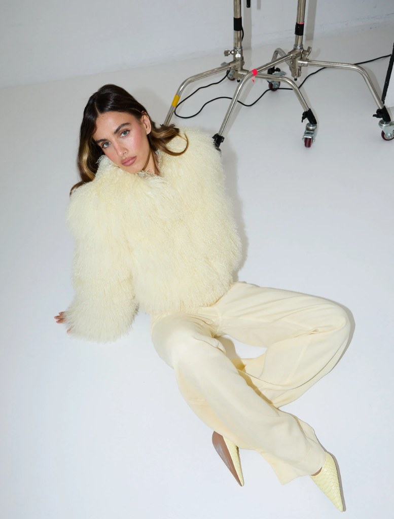 A woman sporting pale yellow pants and a blouse, representing a trendy ensemble.