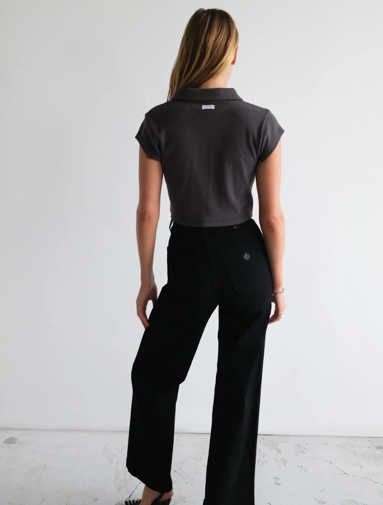 Charcoal Addison Polo shirt draped over a chair, emphasizing its sleek design and comfortable fabric.