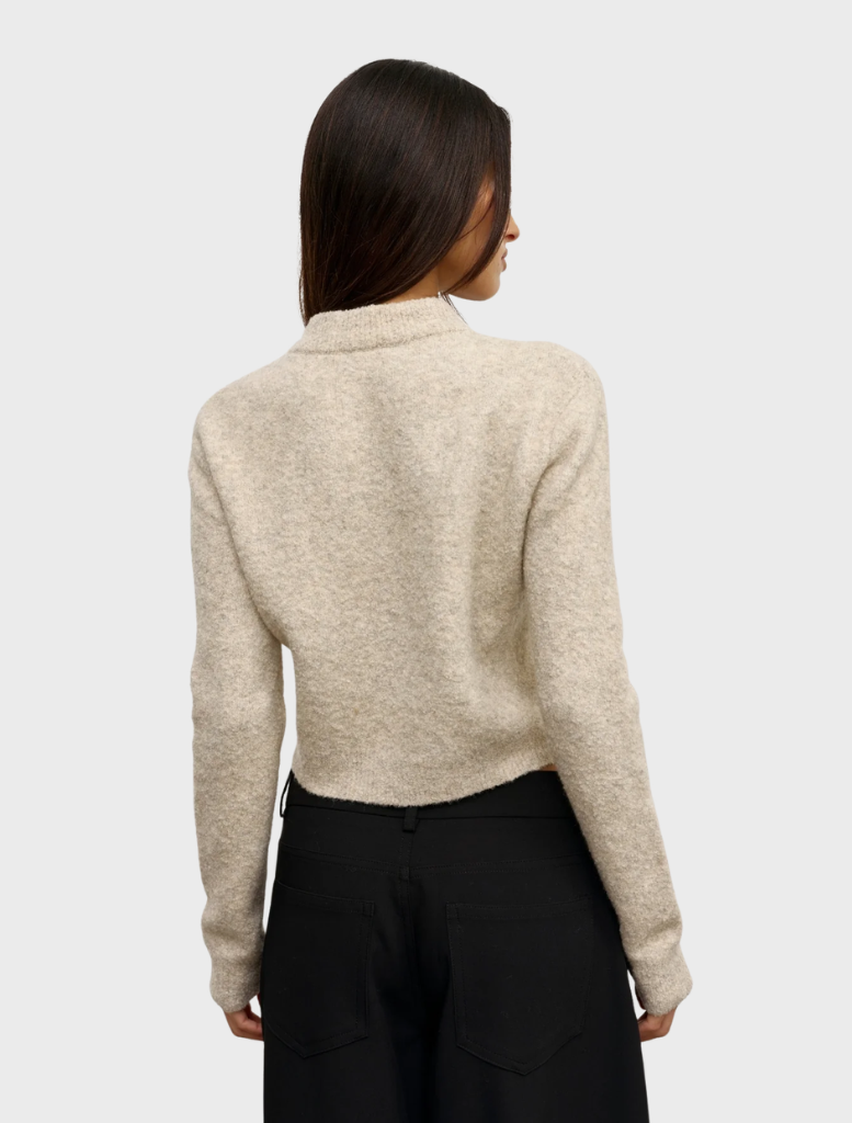 The Claudia V Knit in Urchin, emphasizing its elegant design and vibrant color against a simple backdrop.
