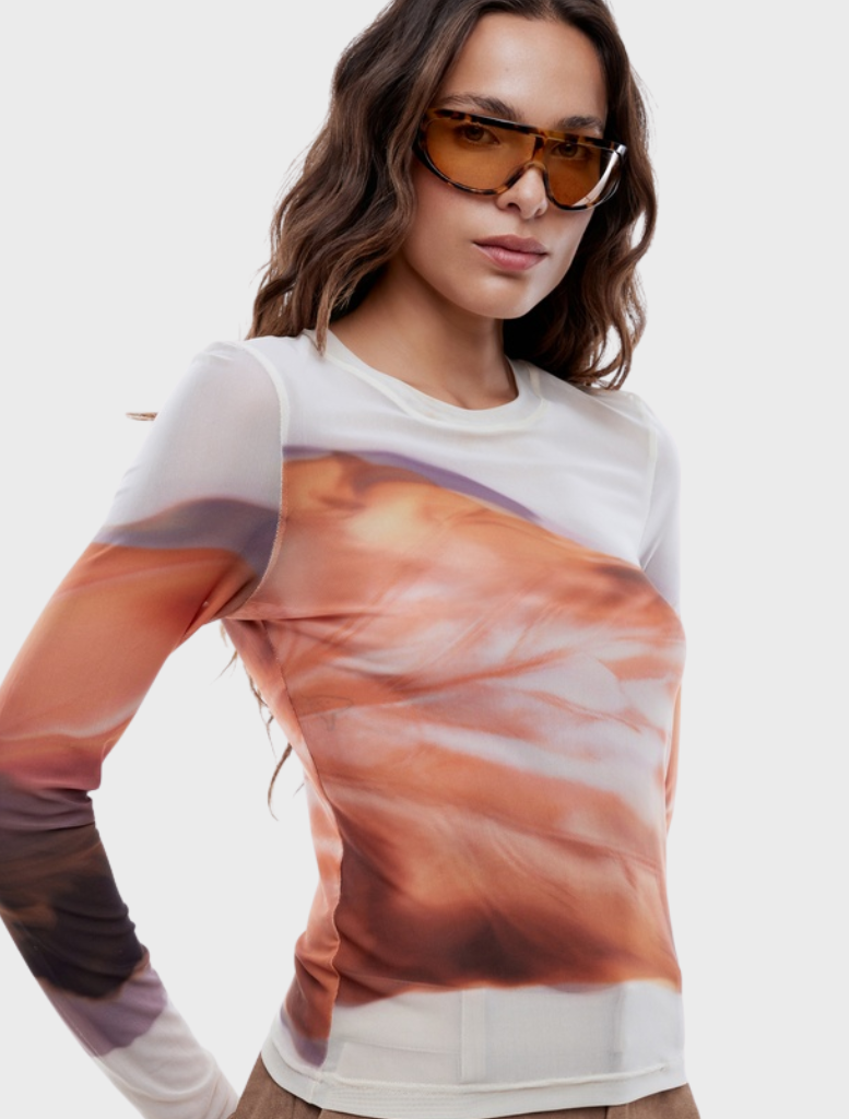 Daisy long sleeve top adorned with a vibrant autumn leaf pattern, ideal for fall fashion.