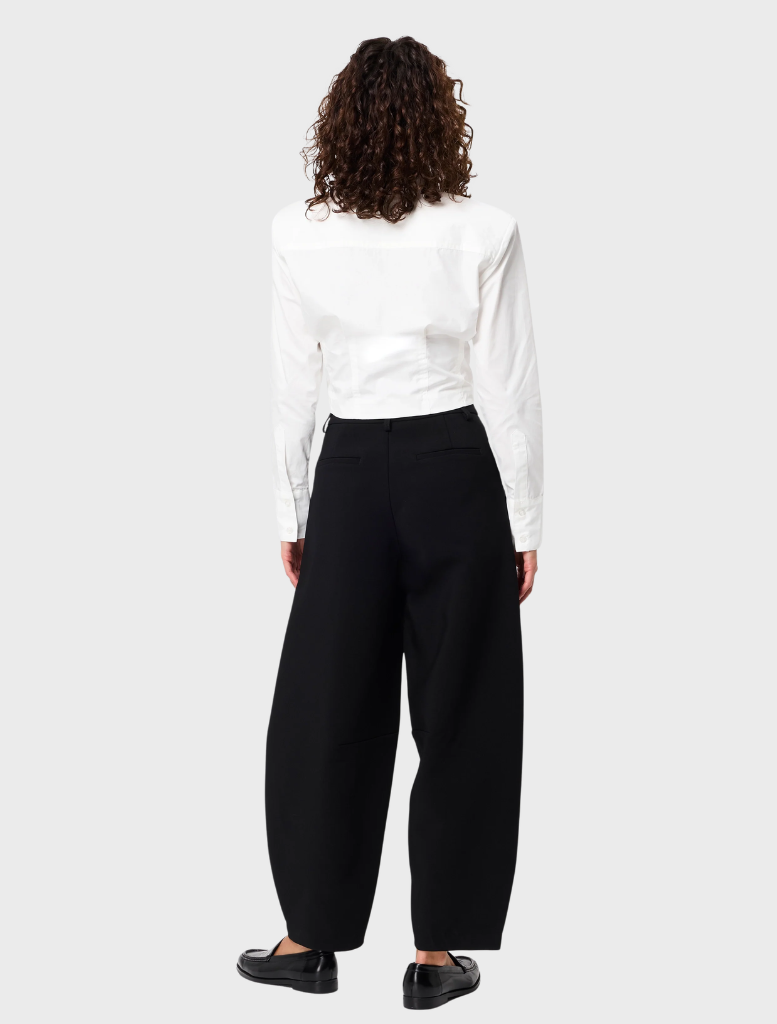 A white Darcy shirt laid flat, showcasing its smooth fabric and tailored design with a button-up front.