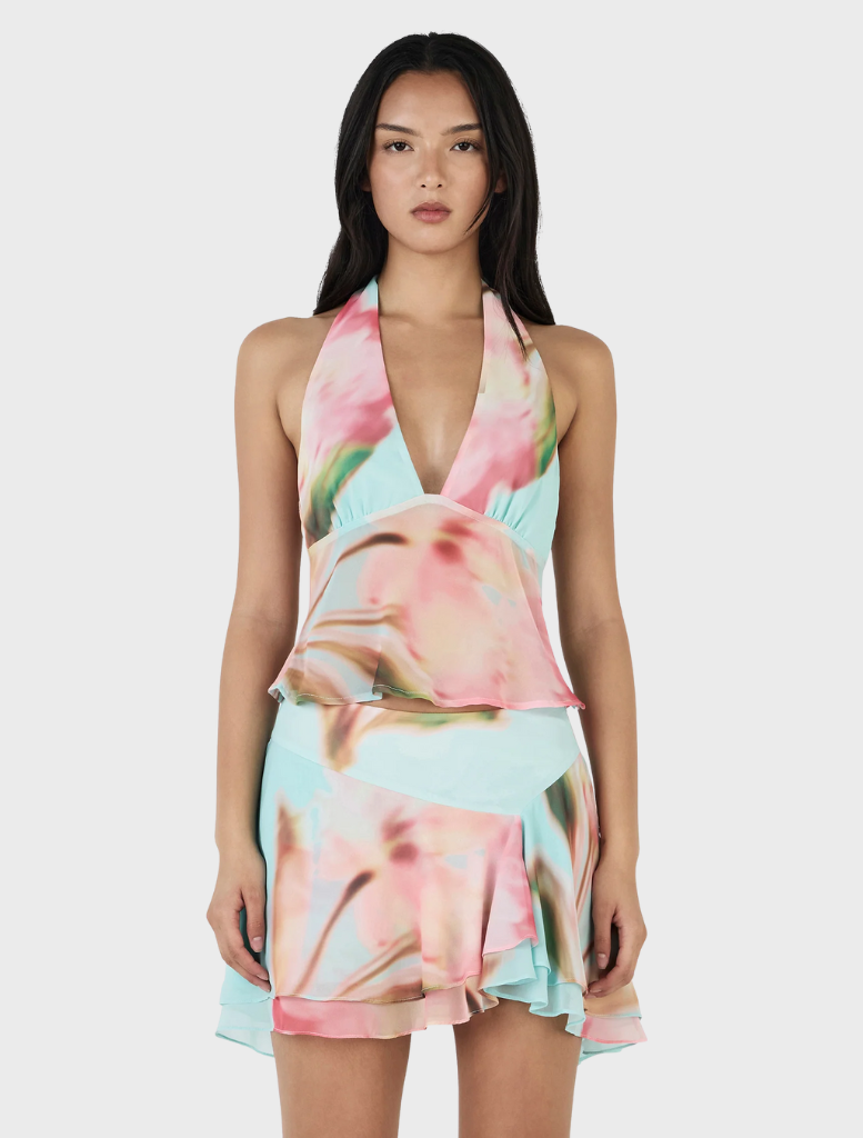 Model in a floral print halter neck dress, named Delilah Scarf Top - Bloom Drift Aqua, showcasing vibrant colors.