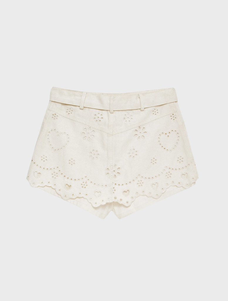 White denim skort with heart eyelet details, combining a trendy look with comfort for warm-weather wear.