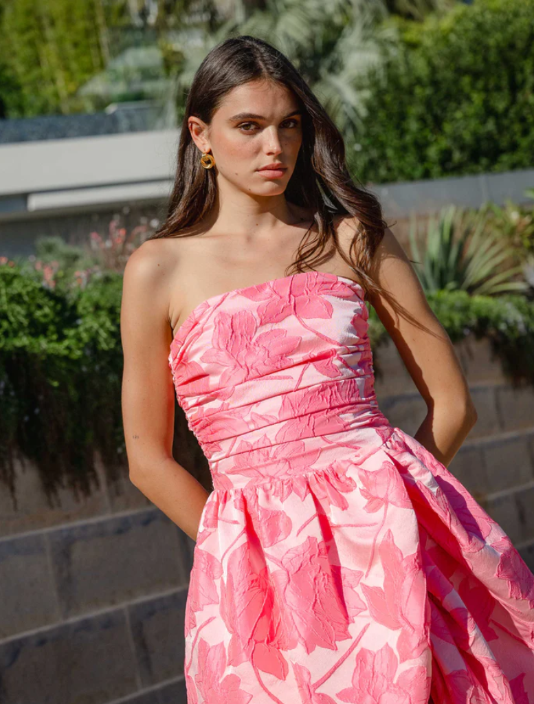 Elegant pink strapless ball gown featuring a structured bodice and a voluminous skirt, ideal for special events.