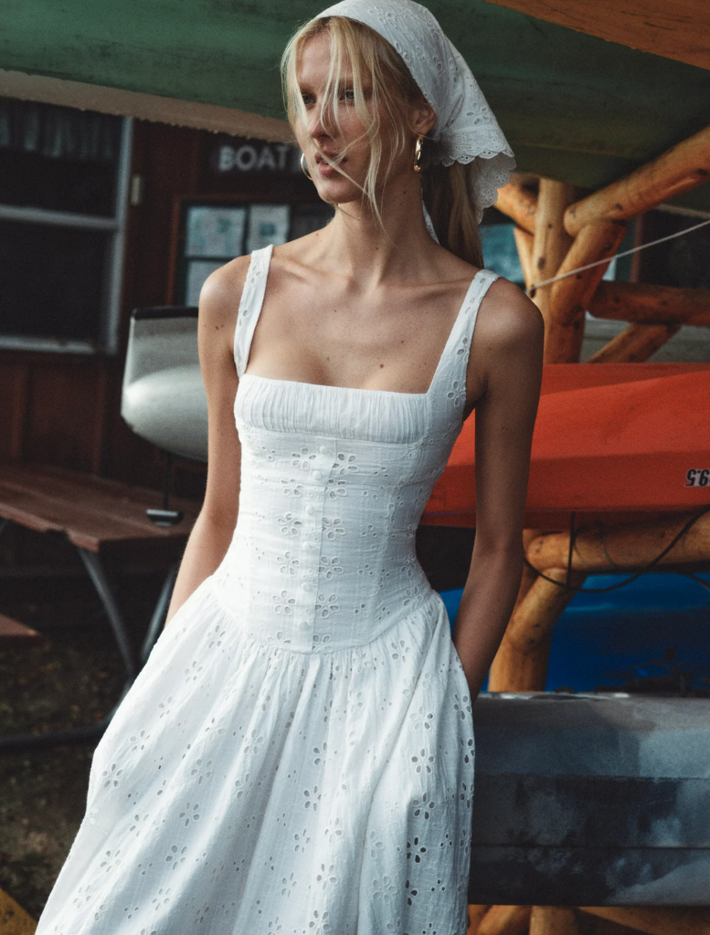 White midi dress with a dreamy daisy print, featuring a flowing silhouette and delicate straps for a feminine look.