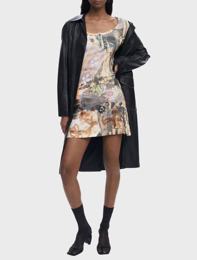 Multi-colored dress with long sleeves hanging on a rack, featuring a modern and eye-catching pattern.