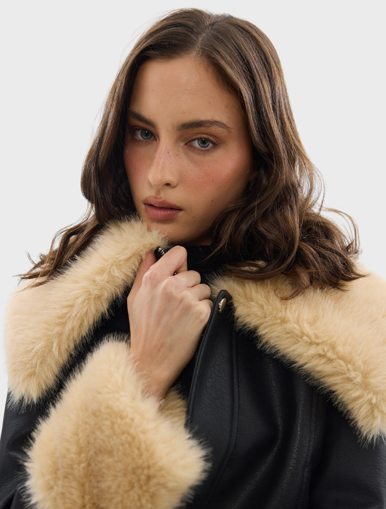 Black Willow jacket draped on a hanger, emphasizing its elegant style and versatile fashion appeal.