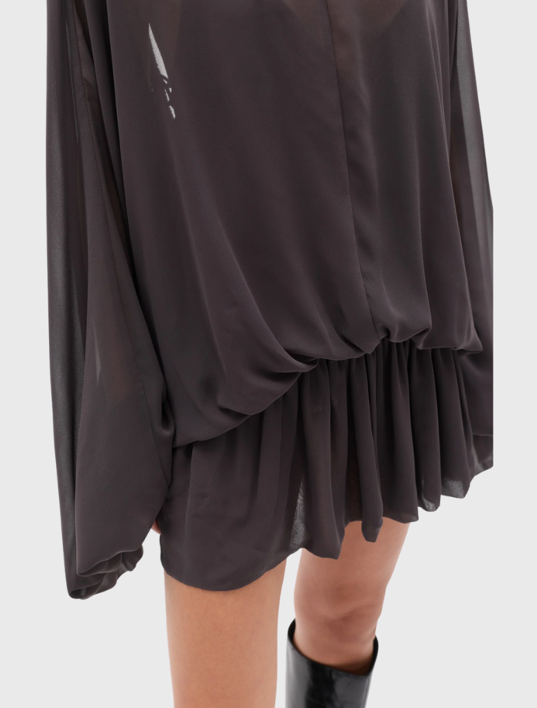 Truffle Evariel Mini Dress includes a boat neckline, sheer upper, voluminous sleeves, gathered waist, and a softly flared mini skirt.