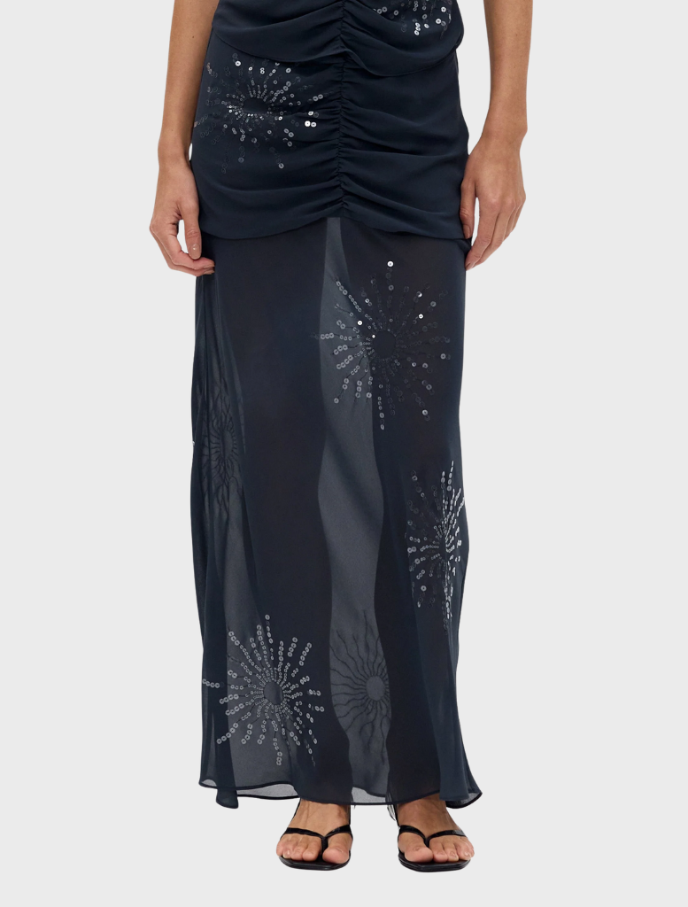 Elegant smoke-colored maxi skirt with a flicker bias cut, perfect for a chic and sophisticated outfit.