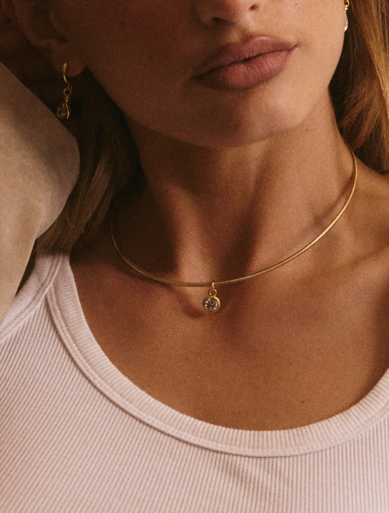 The Georgia Stone Omega Necklace: a gold choke style adorned with a sparkling diamond charm.