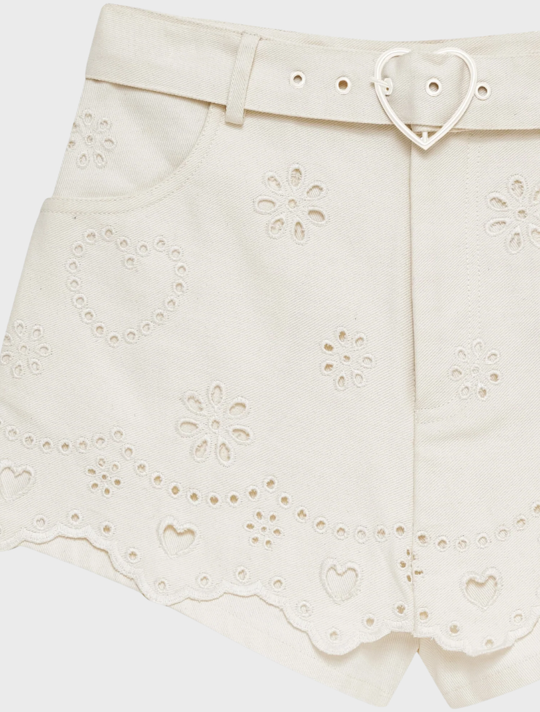White heart eyelet denim skort featuring a playful design, perfect for casual summer outings and stylish comfort.