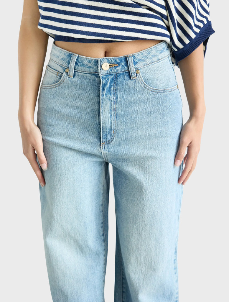 A woman showcases the 94 High & Wide style by Jody Blue, wearing wide-legged jeans paired with a striped top.