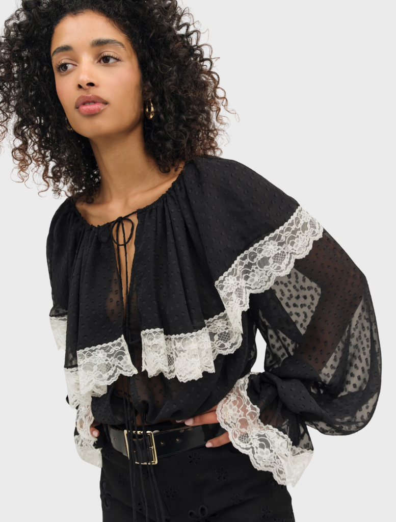 Black June top displayed on a hanger, featuring a simple design suitable for casual or formal wear.