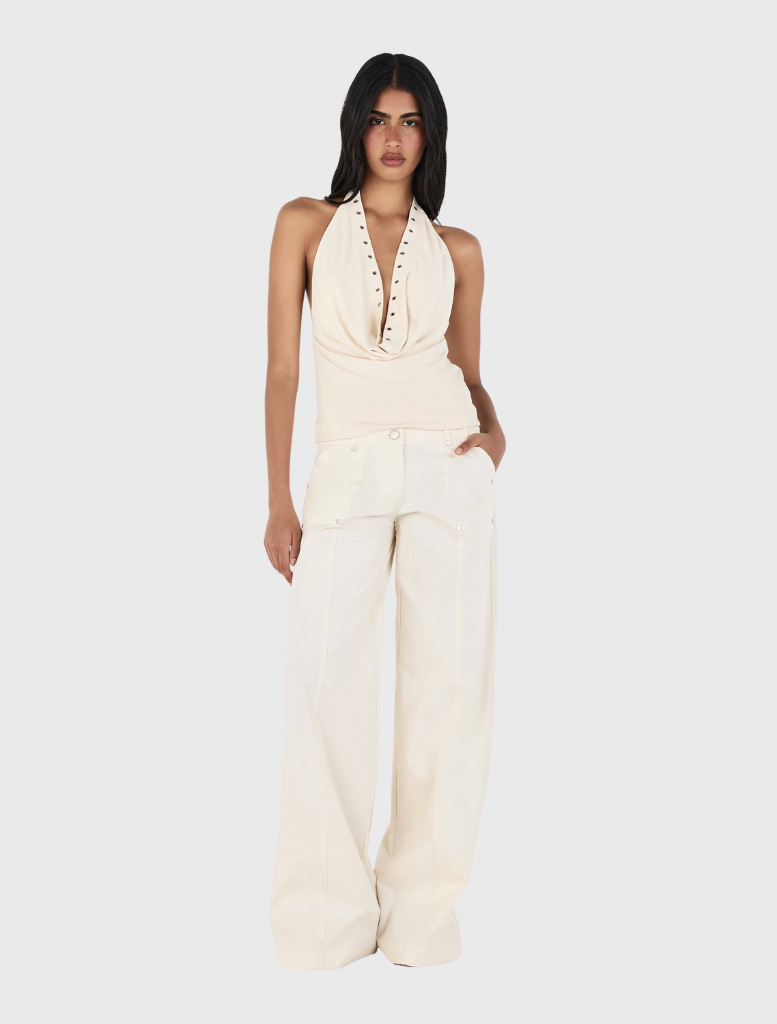 The Kehlani Pant in Cream is a relaxed cargo pant with a low-rise fit, zip fly, belt loops, and front and back pockets.