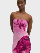 A pink vest hanging on a hanger, featuring a modern cut and fabric texture, ideal for layering in various outfits.