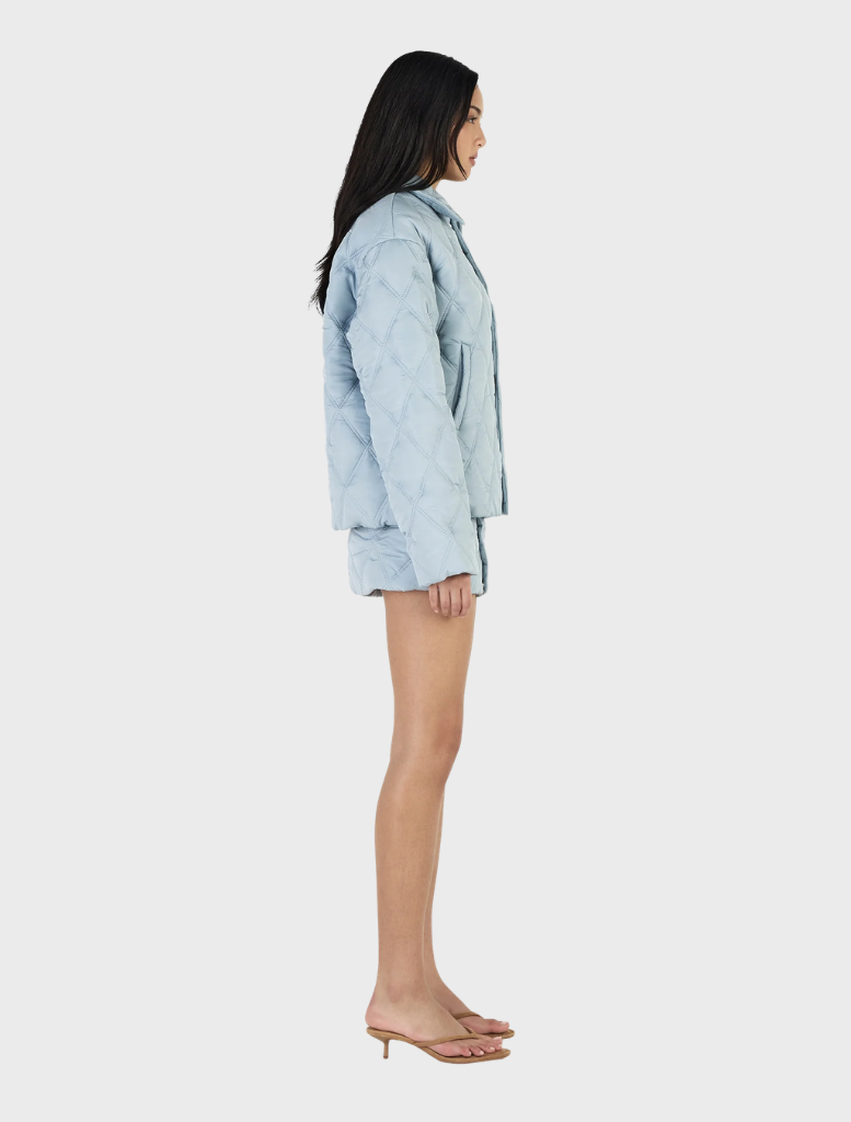 Stylish ice blue quilted jacket from Quinton, ideal for layering and keeping warm during winter outings.