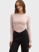 A model showcases a pink top featuring a stylish knot at the front.