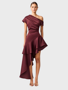 Burgundy satin Livia Gown with an asymmetric hem, elegantly draping for a sophisticated look.