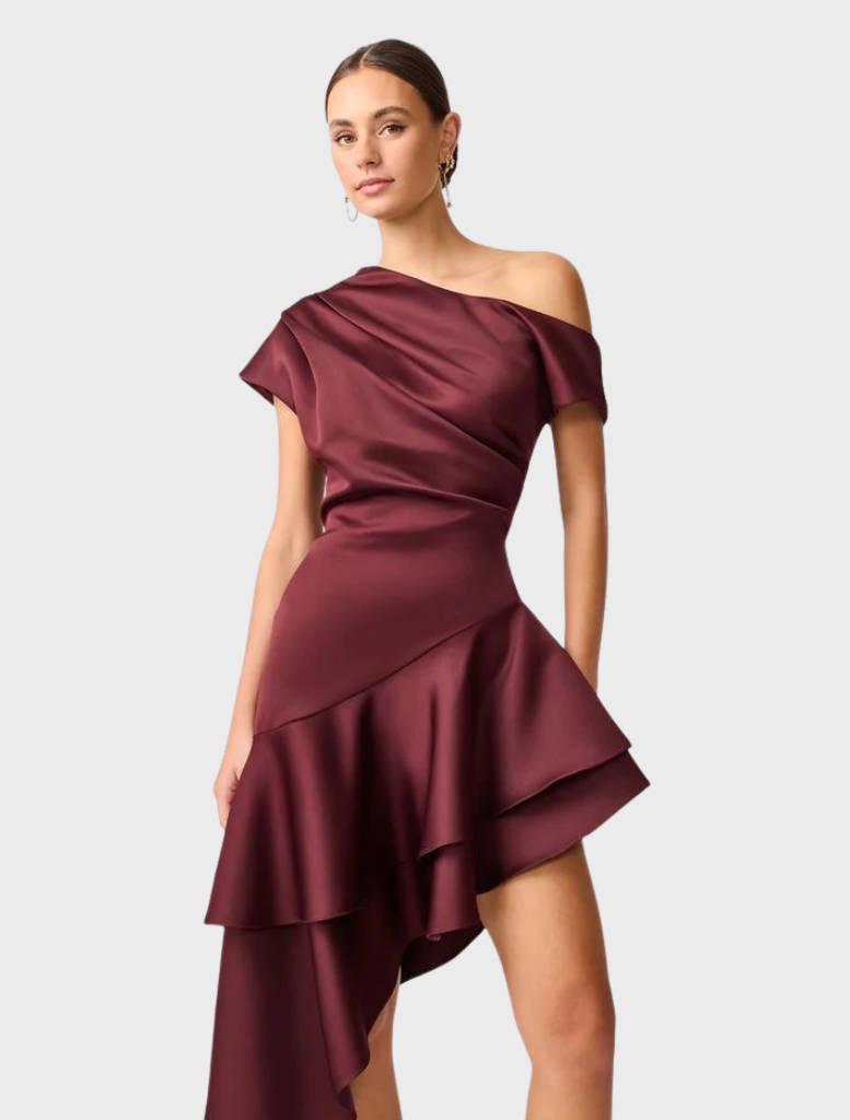 Elegant burgundy satin Livia Gown with a unique asymmetric hem, ideal for special events.